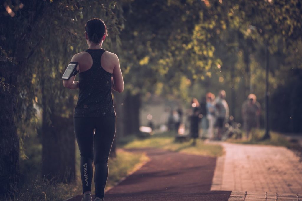 Image of a person running through a park.