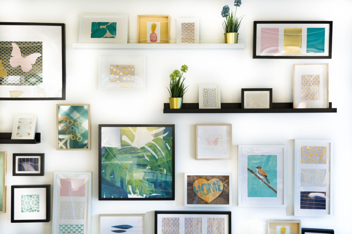 Lots of framed posters and pictures adorning a plain, white wall