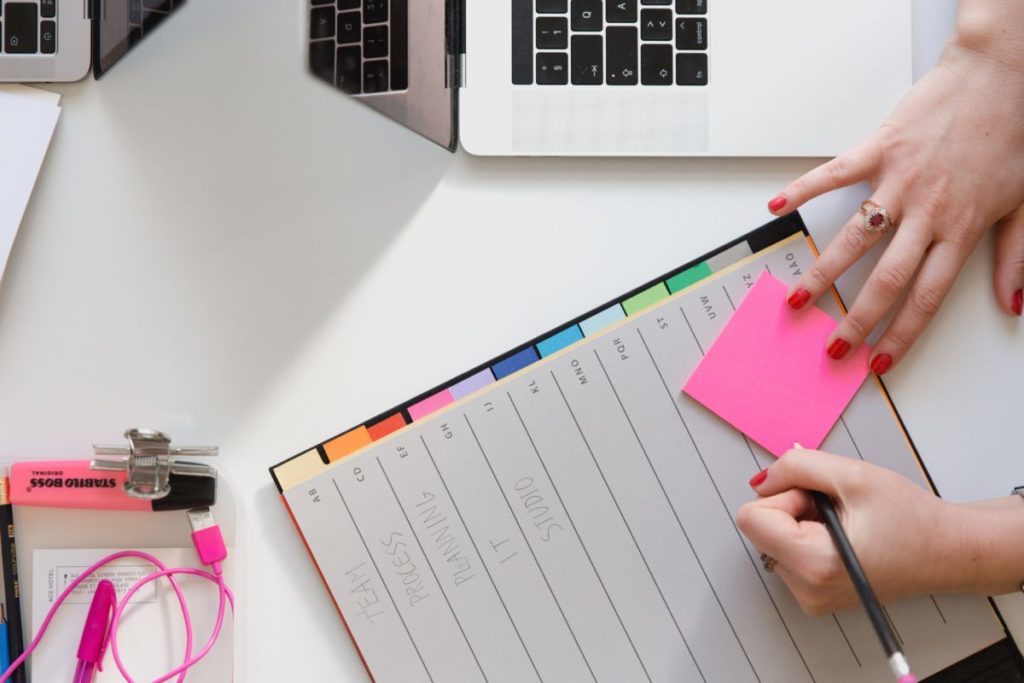 Person writing on post-it notes.