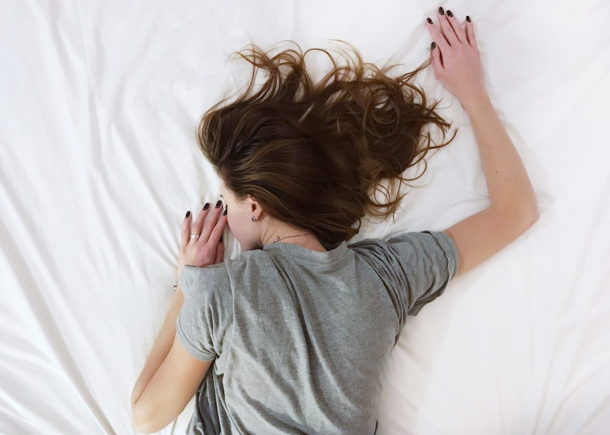 Image of a woman sleeping face down on a bed.