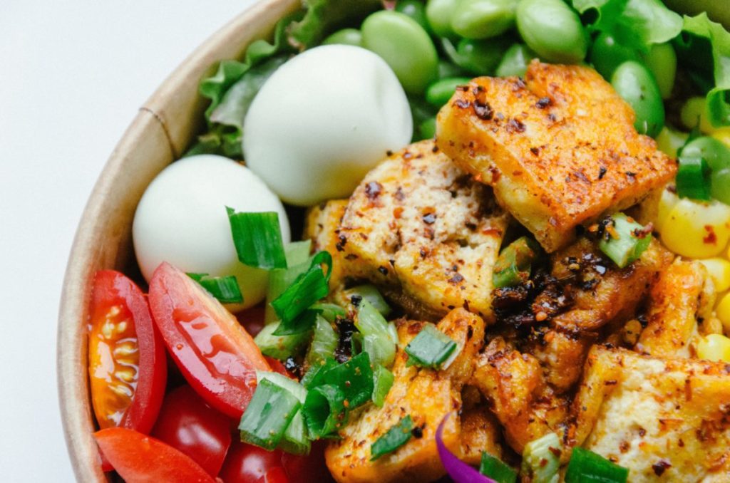 Healthy meal of boiled eggs, tomatoes, tofu and beans.