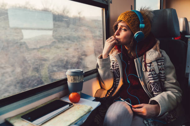 Image of woman wearing headphones travelling on a public train