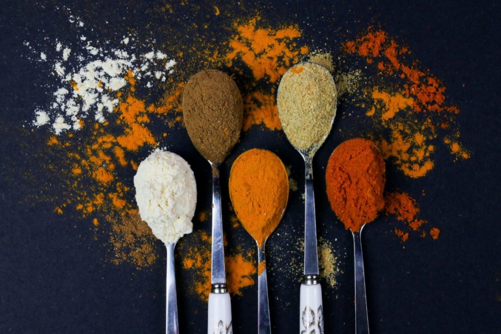 Five spoons with different spices