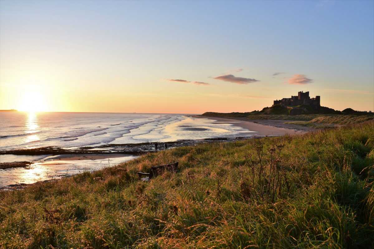 Bamburgh Castle seen from a distance at sunrise.