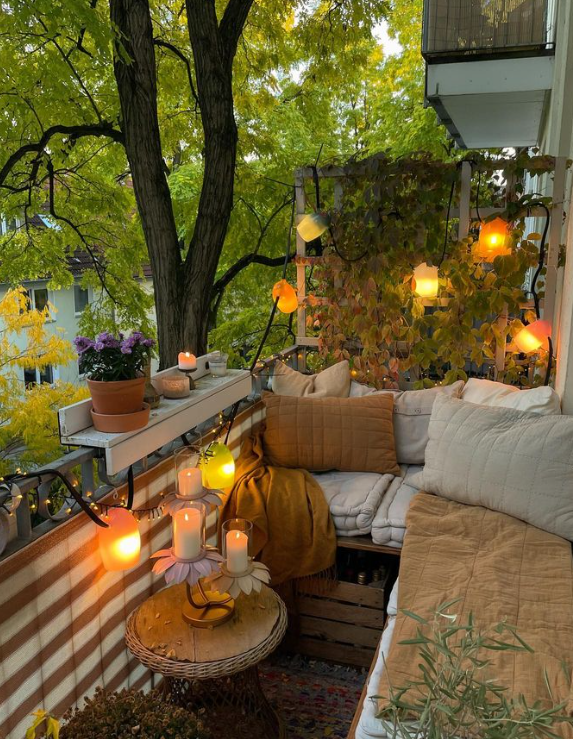 Cosy balcony with corner seating, soft furnishings and string lights.