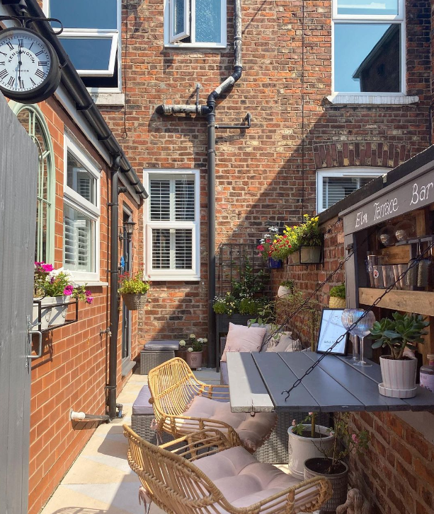 Foldaway bar made from upcycled pallets attached to a brick wall in this yarden.