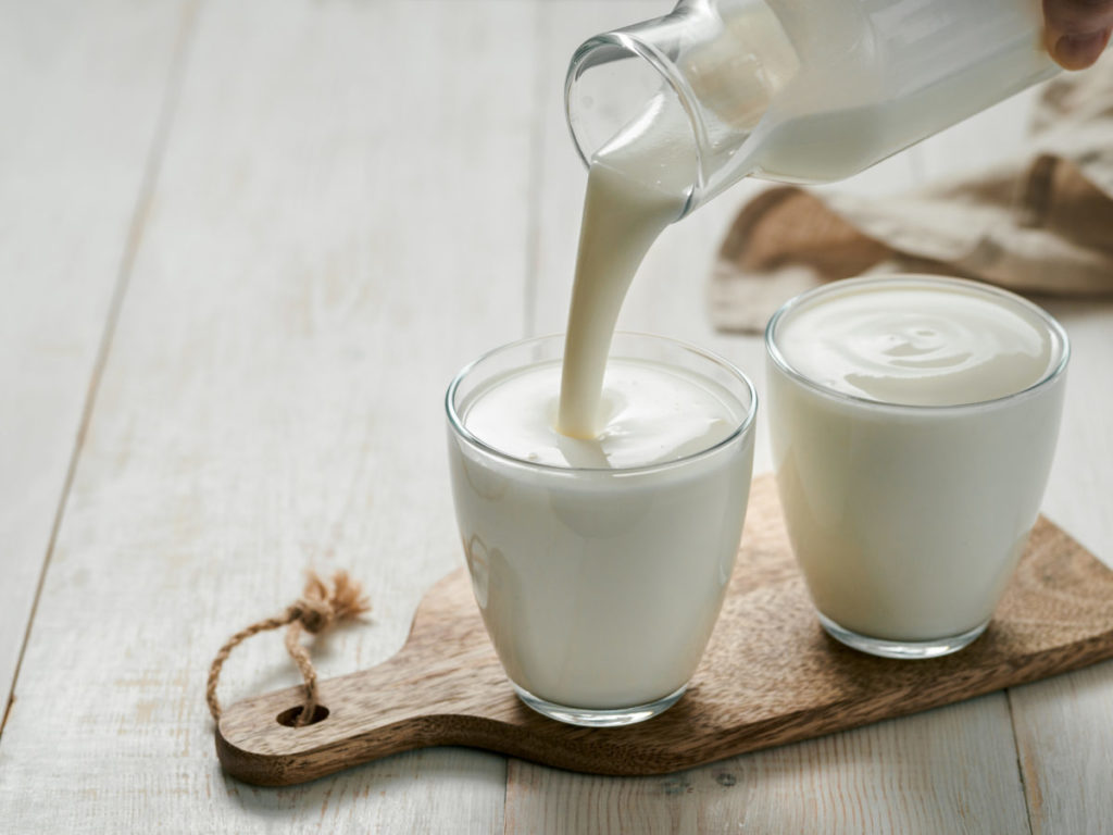 Pouring lassi into a glass.