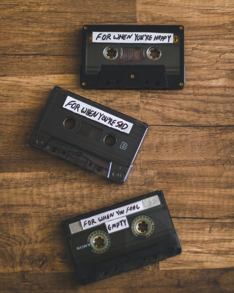 Three mix tapes on a table - labelled as "for when you're happy", "for when you're sad" and "for when you feel empty."