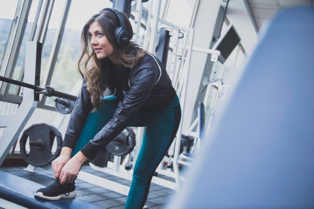Woman working out in the gym wearing headphones.