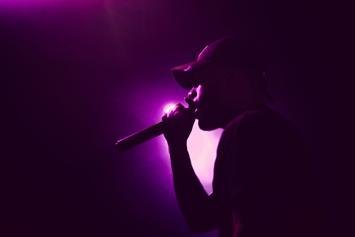 Man standing under stage lights singing karaoke