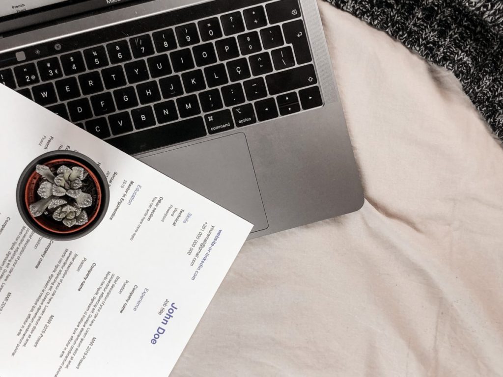 Image shows a CV laid on a laptop.