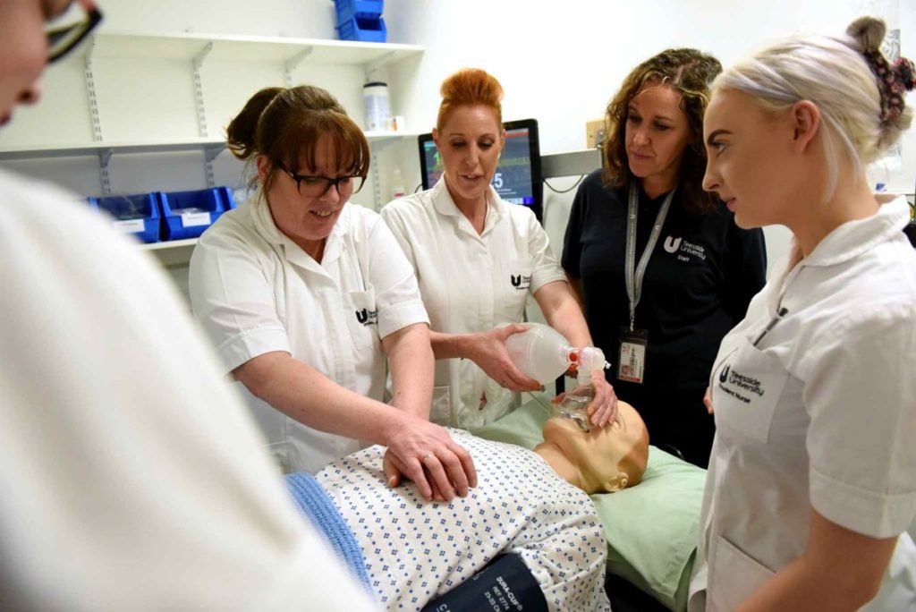 Student nurses performing CPR on sim dummy