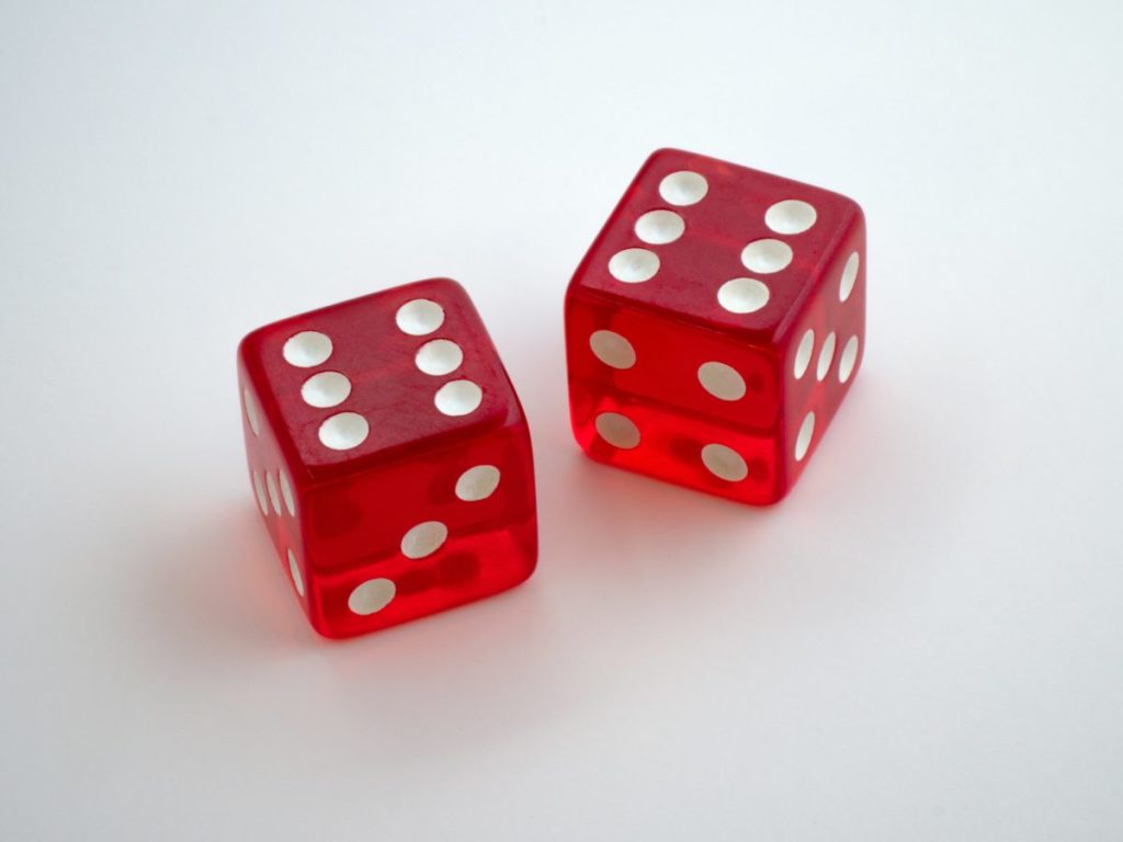 Red dice showing double six on a white table