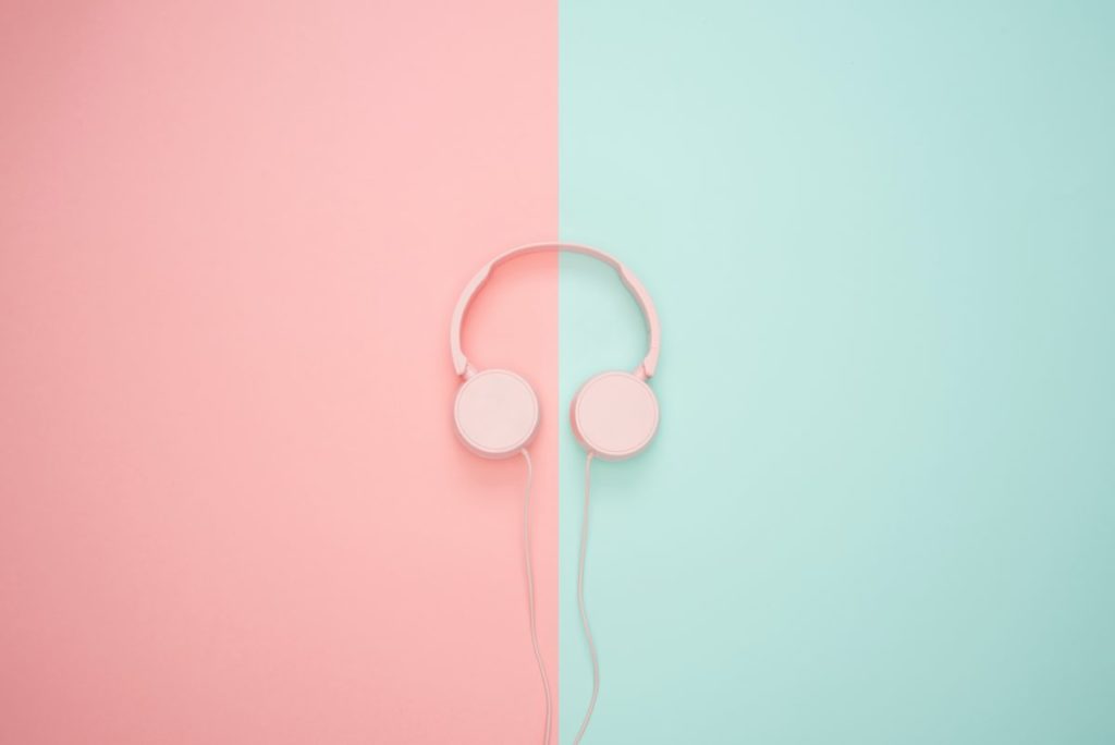 Pink headphones on a blue and pink background.