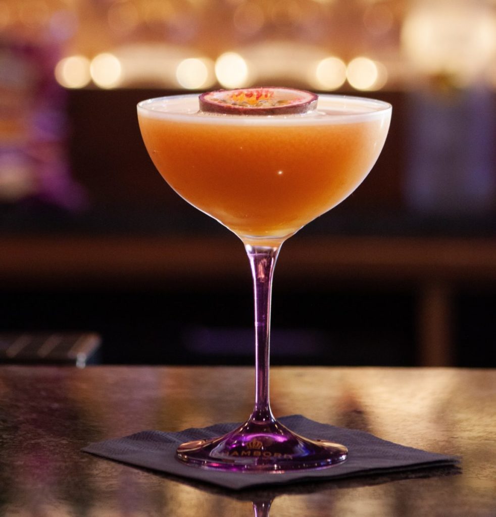 Passionfruit martini in a cocktail glass, placed on a bar.