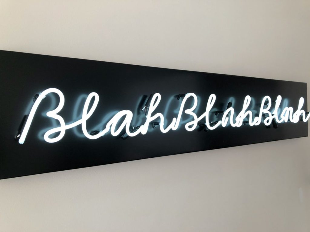 Neon text on a black sign reading 'blah blah blah'