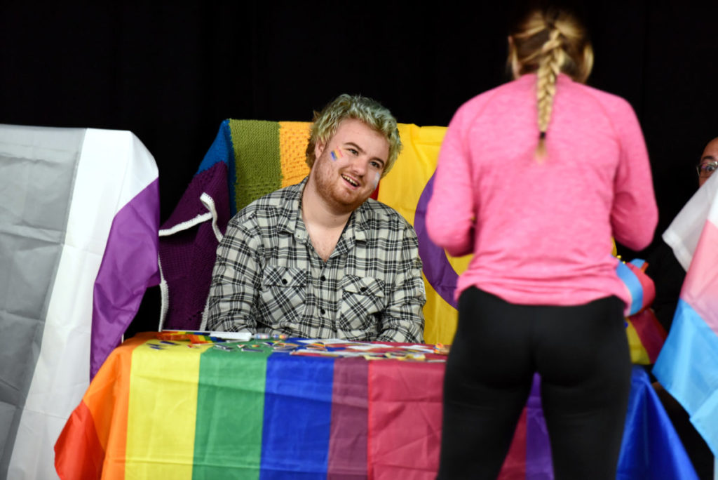 A society member behind a table speaking to a student at the societies fair