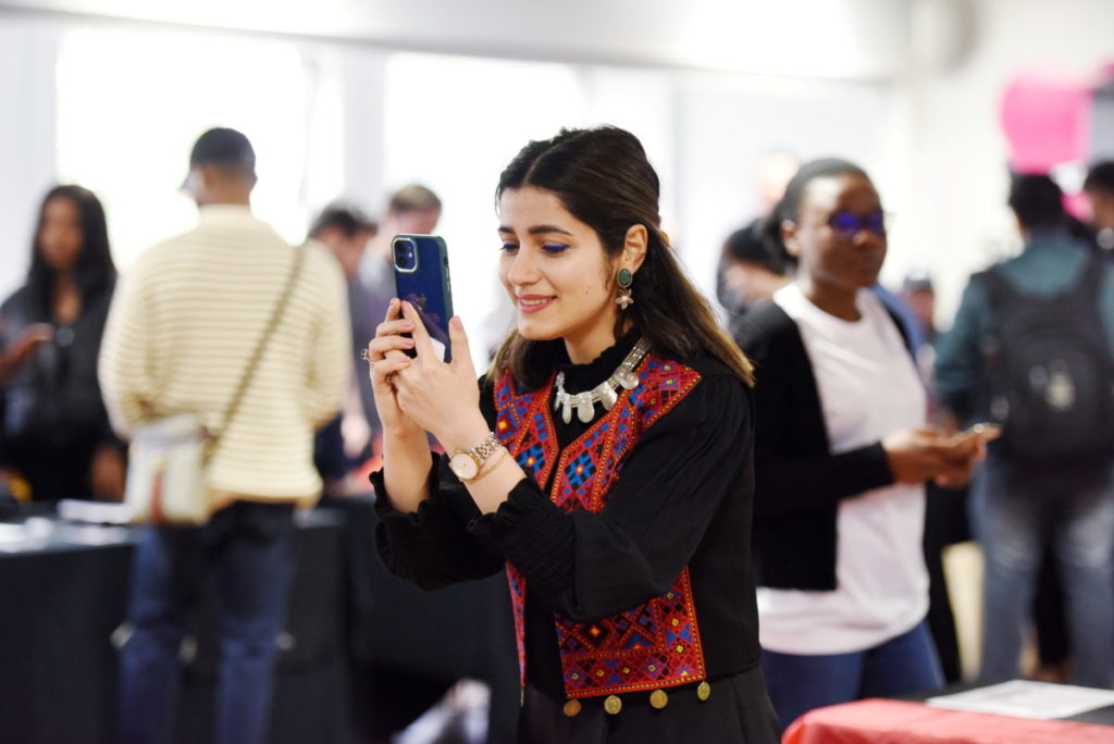 A student using their phone at the societies fair