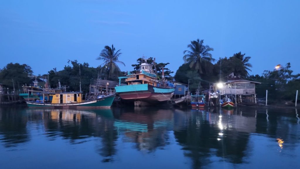 Boats and palm trees line the harbour