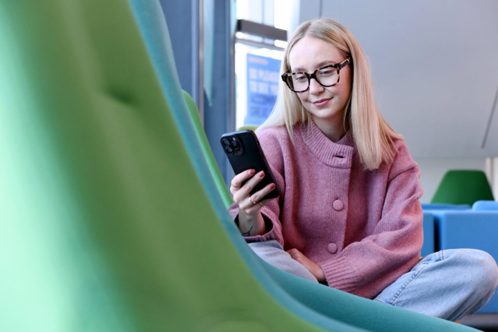 A student scrolling on their phone